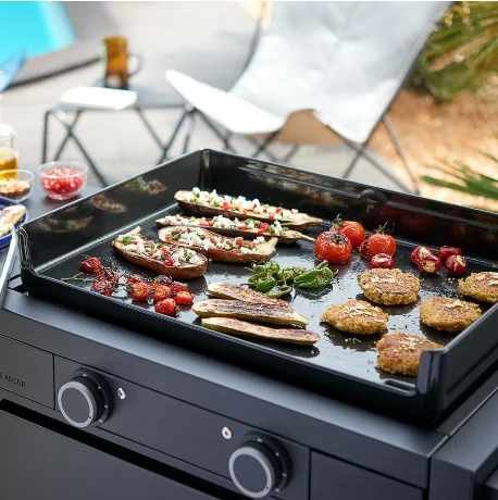 Food cooking on a gas plancha grill